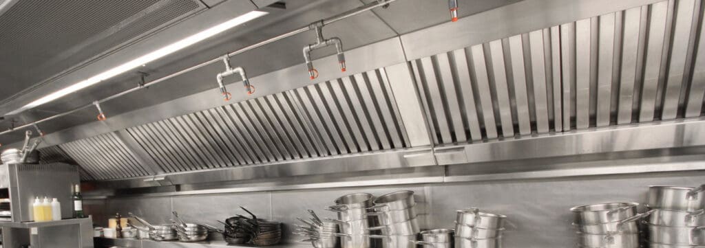 Stainless steel kitchen exhaust hood and pots.