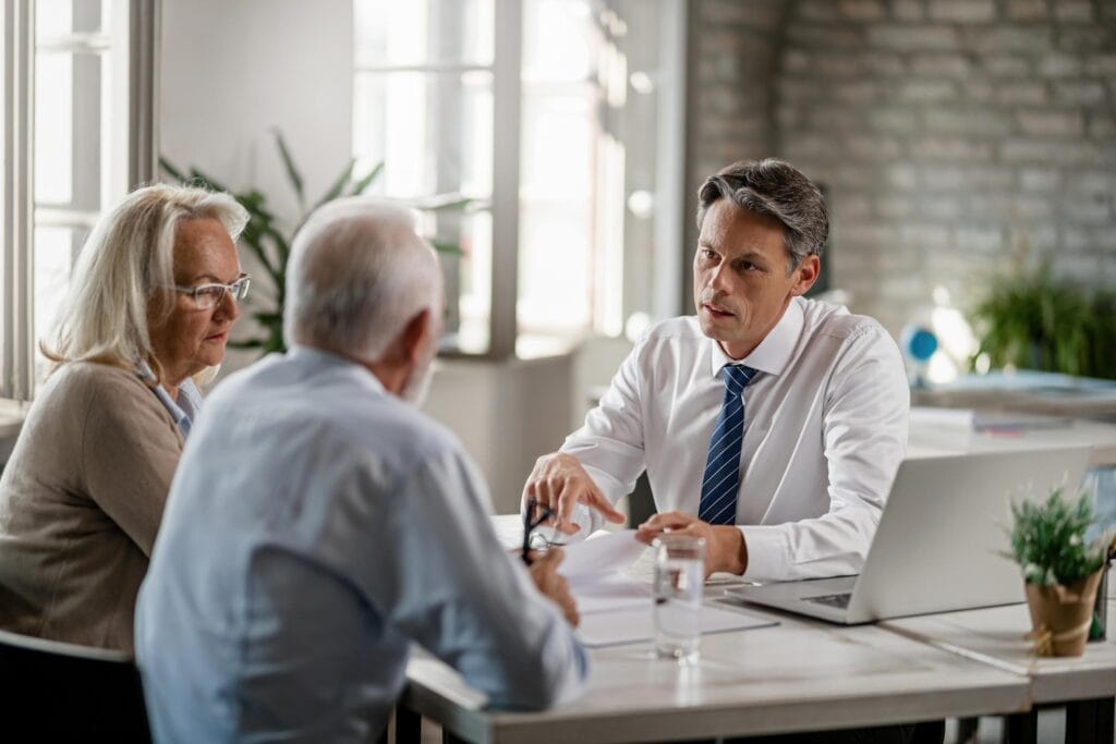 Financial advisor meeting with older couple in office.